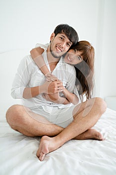 Happy young couple relaxing in the home bedroom.