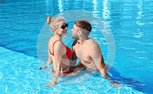 Happy young couple relaxing in swimming pool