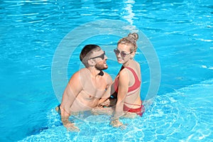 Happy young couple relaxing in swimming pool