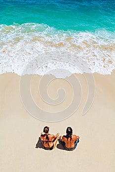 Happy young couple relaxing on white sand sea beach