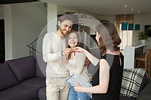 Happy young couple renters getting keys of new rental home