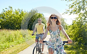 Happy young couple riding bicycles in summer