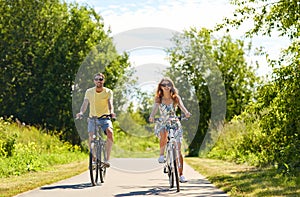 Happy young couple riding bicycles in summer