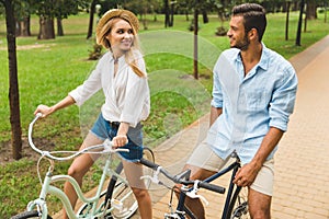 happy young couple riding bicycles together