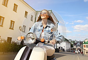 Happy young couple riding scooter in town. Handsome guy and young woman travel. Adventure and vacations concept.