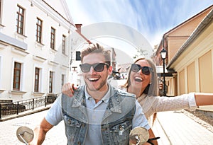 Happy young couple riding scooter in town. Handsome guy and young woman travel. Adventure and vacations concept.