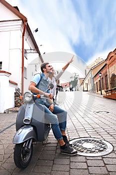 Happy young couple riding scooter in town. Handsome guy and young woman travel. Adventure and vacations concept.