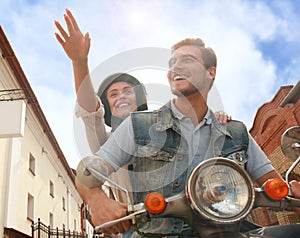 Happy young couple riding scooter in town. Handsome guy and young woman travel. Adventure and vacations concept.