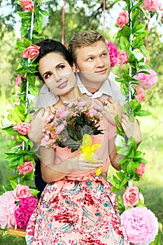 Happy young couple riding on a swing