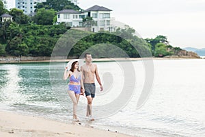 Happy young couple romantic lifestyle walking on tropical beach