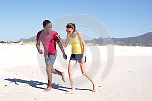 Happy young couple running on beach together