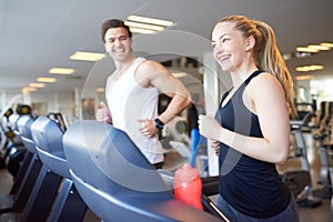 Happy Young Couple Running on Treadmill Device
