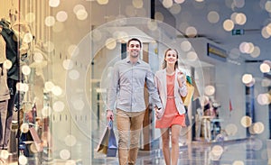 Happy young couple with shopping bags in mall