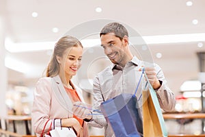 Happy young couple with shopping bags in mall