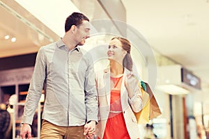 Happy young couple with shopping bags in mall