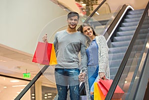 Happy young couple shopping and holding bags