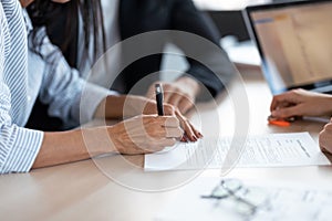 Happy young couple signing bank loan agreement with real-estate agent to buying the house in the office