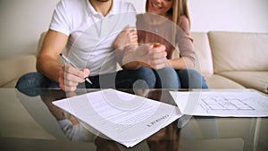 Happy young couple signing contract agreement and hugging, mortgage investment