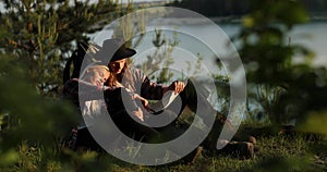 Happy young couple sitting on the background of the lake, they looking on the map. They discuss on what what way they