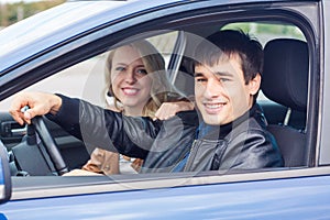 Happy young couple sitting in the car