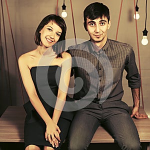 Happy young couple sitting on desk at apartment