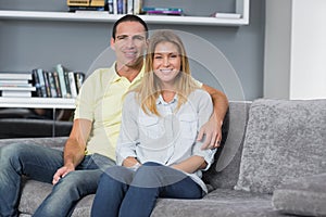 Happy young couple sitting on their couch