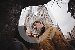 Happy young couple smiling outdoors looking at each other with love.