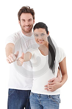 Happy young couple smiling showing thumb up