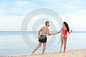 Happy young couple spending time  on beach near sea