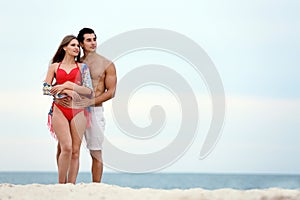 Happy young couple spending time  on sea beach. Space for text