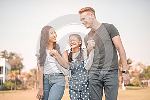 Happy young couple spending time with their daughter in park.The concept of a happy family