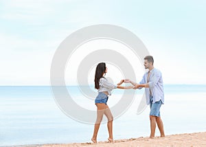 Happy young couple spending time together on beach