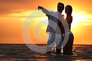 Happy young couple spending time together on sea beach at