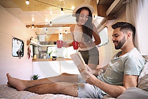 Happy young couple spending time together in trailer. Camping vacation