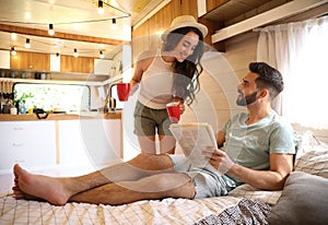 Happy young couple spending time together in trailer. Camping vacation