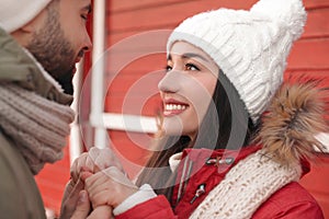 Happy young couple spending time together at winter fair. Christmas celebration