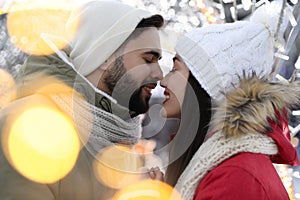 Happy young couple spending time together at winter fair. Christmas celebration