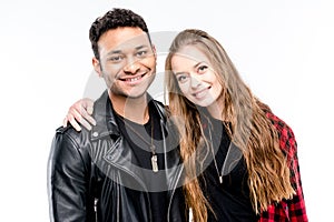 Happy young couple standing embracing and smiling at camera