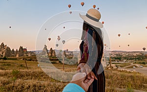 happy young couple during sunrise watching the hot air balloons of Kapadokya Cappadocia Turkey