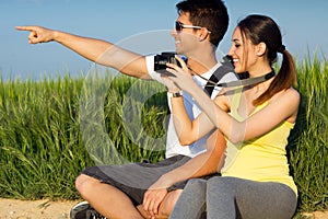 Happy Young couple taking photos in the field