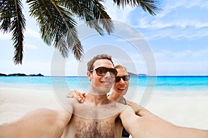 Happy young couple taking selfie photo on the beach