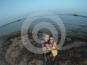 Happy, young couple taking selfy on the beach
