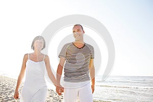 Happy young couple taking a walk on the beach.