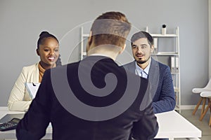 Happy young couple talking to bank manager, insurance advisor or mortgage broker