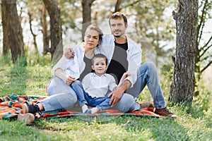 Happy young couple with their children have fun at beautiful park outdoor in nature
