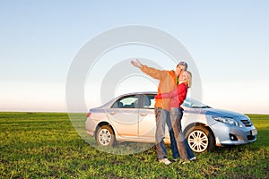 Happy young couple with their new car