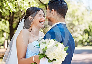 Happy young couple on their wedding day. Husband and wife standing face to face laughing and enjoying romantic moments