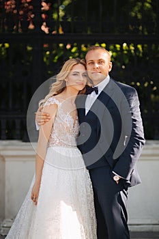 Happy young couple in their wedding day spend time in park. Green background