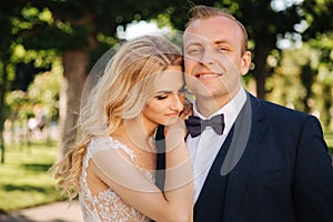 Happy young couple in their wedding day spend time in park. Green background