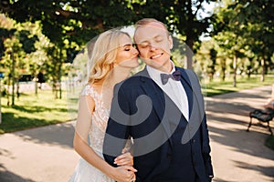 Happy young couple in their wedding day spend time in park. Green background